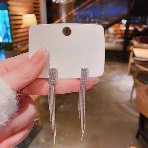 Détail des boucles d'oreilles pampilles émeraude avec aiguille en argent S925 et strass