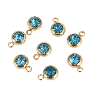Detailed view of round blue crystal birthstone charms with gold plated stainless steel edges