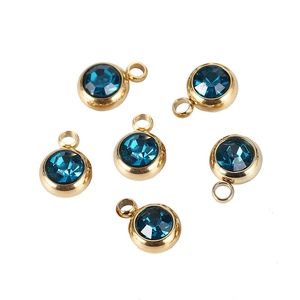 Detail view of 6 gold stainless steel birthstone charms with faceted navy blue crystals