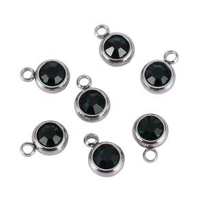 Macro detail of round dark green emerald crystals with silver stainless steel bezels