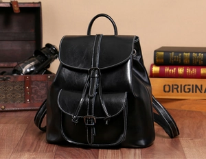 Detail of oil wax leather backpack showing glossy texture and silver metal buckle