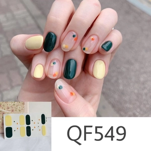 Close-up of QF549 matte daisy nail stickers in dark green, cream yellow and polka dots
