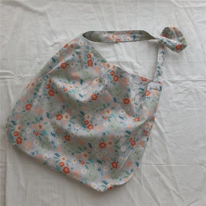 Close-up of a floral cotton tote bag with daisy patterns and adjustable shoulder strap