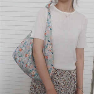 Detail of floral cotton hobo bag showing daisy pattern and wide shoulder strap