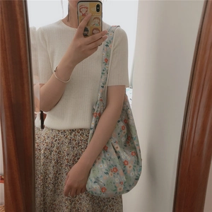 Mirror selfie showing the large floral canvas tote bag on the shoulder for sizing