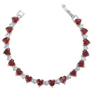 Macro shot of silver heart bracelet featuring red heart stones and brilliant zircon accents