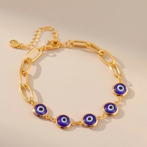 Detail of gold chain Evil Eye bracelet with five blue glass charms and lobster clasp