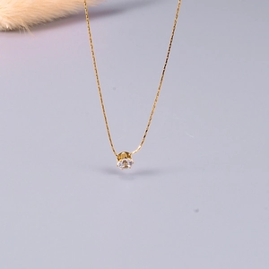 Close-up of a 18K gold plated titanium necklace with a claw-set cubic zirconia pendant