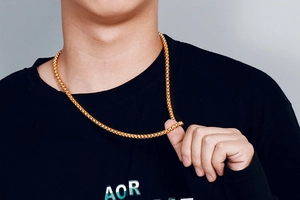 Macro shot of polished gold-plated stainless steel box chain necklace on model skin