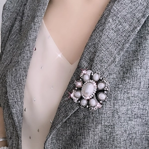 Baroque floral pearl brooch with rhinestones on a grey suit lapel for elegant women