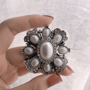 Baroque vintage pearl brooch with silver metal base and crystals held by hand