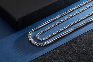 Close-up of silver stainless steel Cuban link necklaces with polished metallic finish