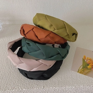 Vertical stack of braided satin headbands in green, orange, pink, and black colors