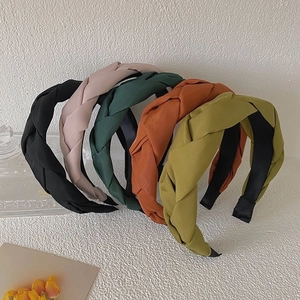 Detail view of woven braided headbands in black, pink, green, caramel, and yellow shades
