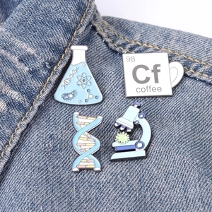 Wissenschaftliche Emaille-Pins Set mit Becher und DNA auf blauer Jeansjacke