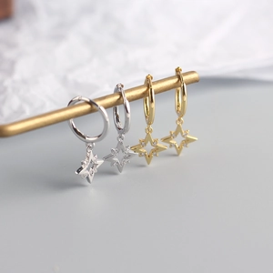 Macro detail of gold and silver S925 sterling silver star earrings with pavé zircons