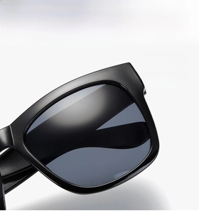 Detail of classic black oversized sunglasses with wide temples and grey gradient lenses