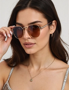Close-up of geometric hexagonal sunglasses with gold metal frame and dark brown lenses