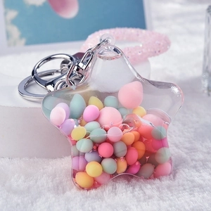 Close-up of star-shaped liquid shaker keychain with colorful beads and pink charm