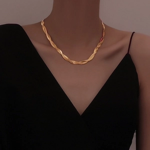 Elegant gold double-layered twisted snake bone necklace shown on a model's collarbone