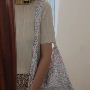 Detailed texture of cotton floral tote bag with small pink flowers and blue leaves