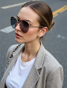 Gros plan sur les lunettes aviateur dorées avec verres dégradés gris sur un mannequin
