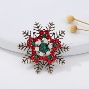 Festive snowflake brooch with red and green rhinestones on a vintage gold metal base