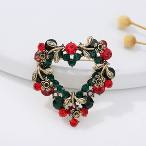 Vintage heart-shaped Christmas brooch with red and green crystals in antique gold