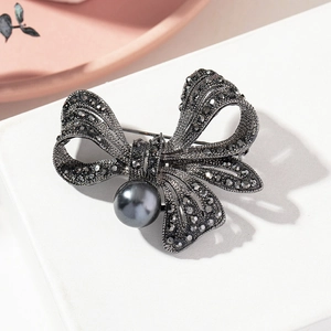 Detail of vintage bow brooch with dark grey pearl and pavé set charcoal crystals