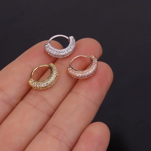 Sparkling zircon hoop earrings in silver, gold, and rose gold finishes on fingertip
