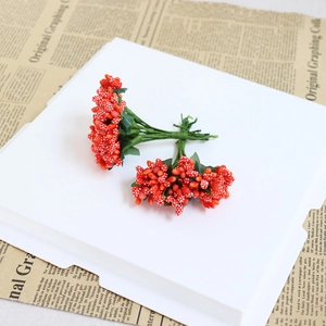 Détail de baies rouges à pois faits main avec tiges vertes pour bricolage de mariage