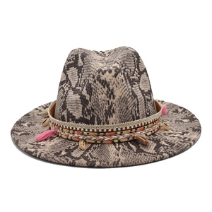 Détail du chapeau fedora motif serpent avec ruban ethnique et pompon rose décoratif