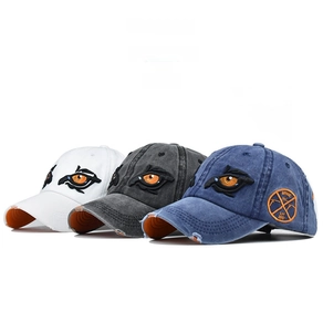 Detail of washed cotton baseball caps featuring cartoon eye embroidery in multiple colors