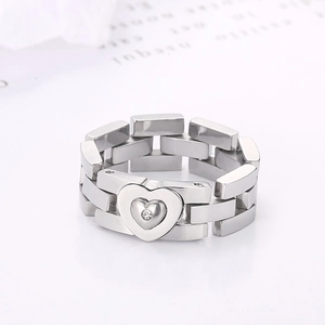 Macro detail of silver stainless steel chain ring with heart ornament and small gem