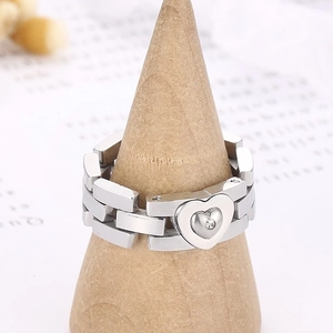 Macro view of silver chain ring featuring a heart charm with a small center diamond