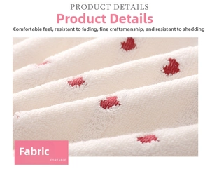 Detail of soft white cotton towel with red heart jacquard pattern and plush texture