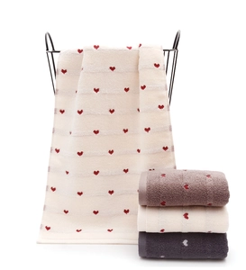 Detail view of thickened heart pattern towels in cotton hanging and stacked neatly