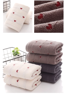 Close-up detail of soft cotton loops and delicate red heart embroidery on towels