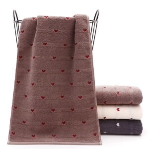 Close-up of thick cotton towels with heart jacquard patterns and soft fabric texture