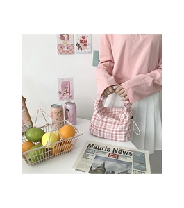 Sac baguette chic à carreaux rose et blanc présenté dans une scène de vie