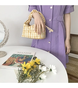 Détail du sac à main en tissu à carreaux jaune et blanc avec des marguerites de printemps
