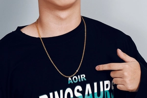Close-up of a gold stainless steel O-link chain necklace worn by a male model