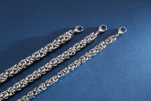 Macro view of three silver stainless steel braided curb necklaces with lobster clasps