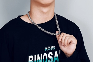 Macro detail of men's stainless steel keel chain necklace worn on male model neck