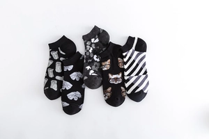 Top view of five pairs of cotton blend crew socks with diverse graphic patterns on white