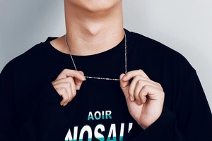 Gros plan d'un collier minimaliste en acier inoxydable argenté porté par un mannequin