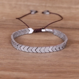 Men's punk handmade braided hematite bracelet with grey arrow-shaped beads on wood