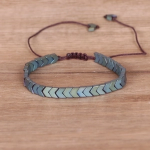 Macro detail of adjustable hematite arrow bracelet with hand-woven brown nylon cord