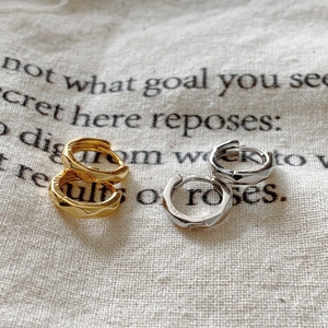 Detail of 925 sterling silver geometric faceted hoop earrings in gold and silver finish