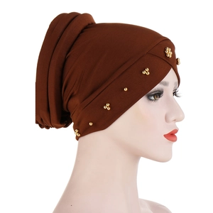 Solid brown turban hat with golden beaded design shown on a side-view model